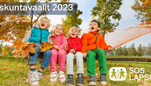 Kuva, jossa neljä lasta istuu riippumatossa ja näyttää huutavan. Laspoilla on värikkäät vaatteet ja tausta on sykyistä luontoa.. Yläkulmassa teksti Eduskuntavaalit 2023 ja alakulmassa SOS-Lapsikylän logo