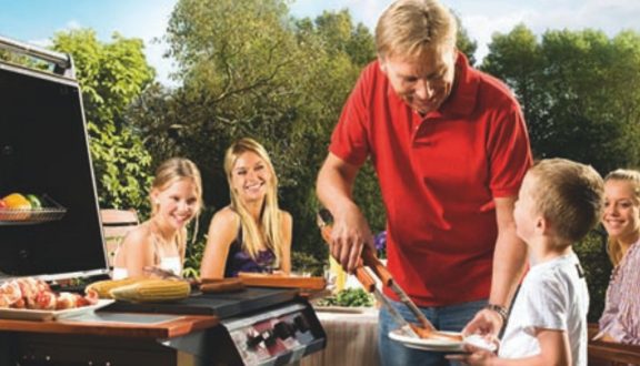 Hyväntuulinen perhe grillaa AGAn nestekaasulla.