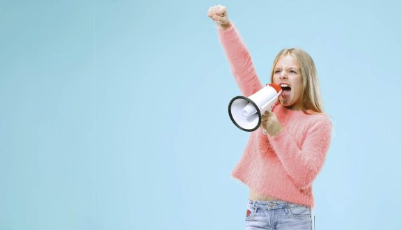 sininen tausta lapsi huutaa megafoniin