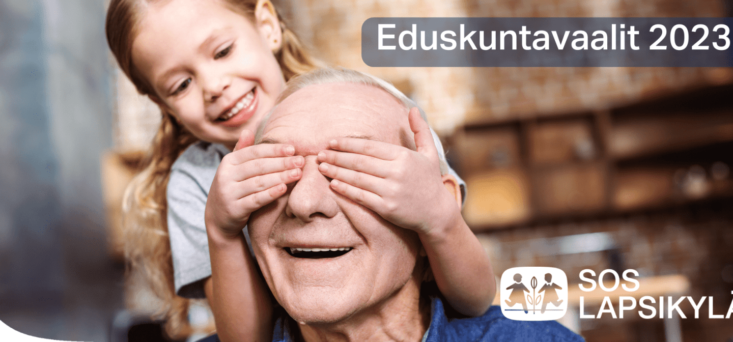 Kuva, jossa leikki-ikäinen tyttö pitää käsiään vanhemman miehen silmien päällä. Molemmat ovat iloisia.