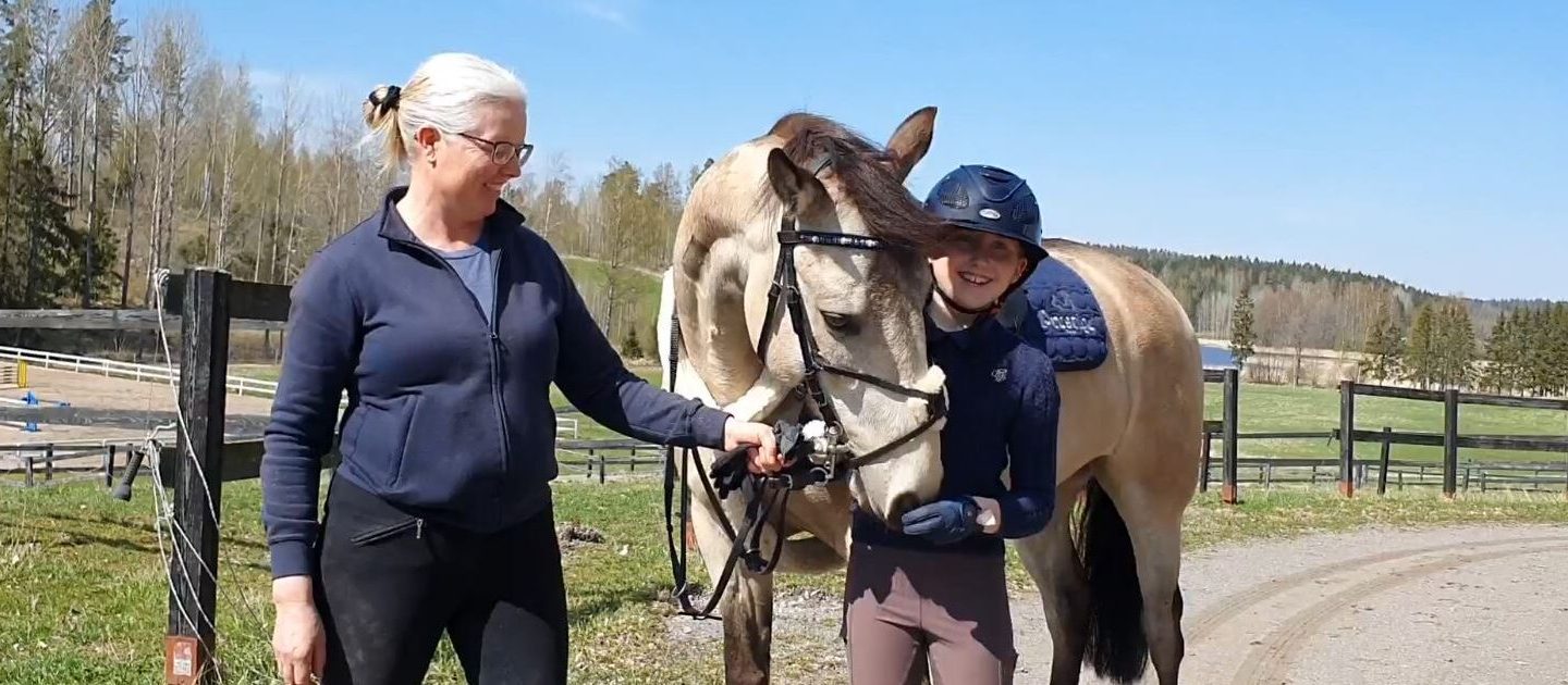 Valmentaja hevosen ja tytön kanssa
