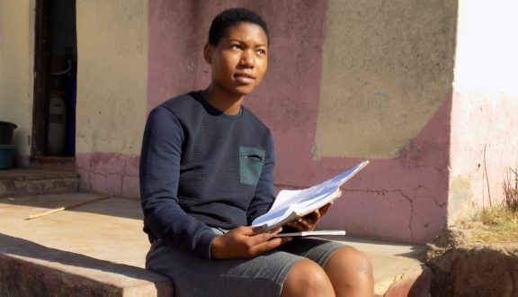 Themba kotinsa edutalla istumassa rappusilla