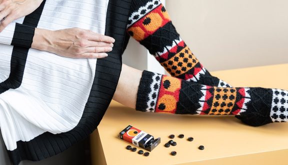 naisen jalat, joissa kuviolliset sukat ja karkkeja vieressä