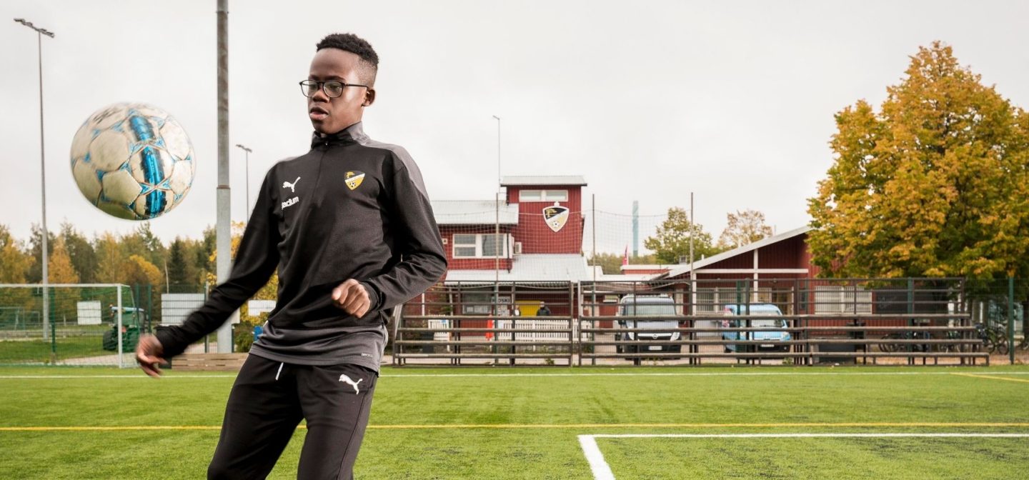 Jalkapalloilija Adiche Sabwele pomputtelee palloa jalkapallokentällä