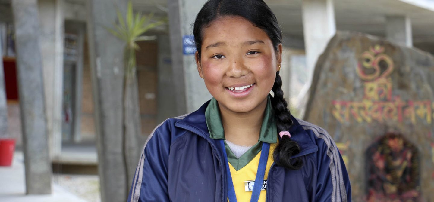 Nepalilainen koulutyttö hymyilee