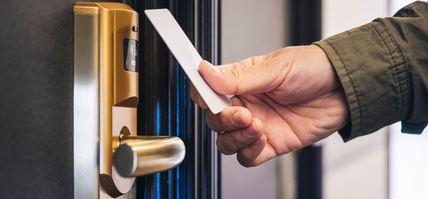 Henkilö avaa hotellihuoneen ovea