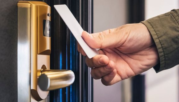 Henkilö avaa hotellihuoneen ovea