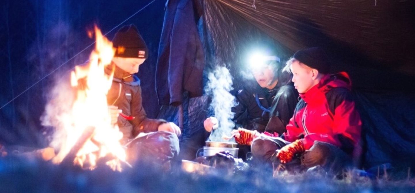 Partiolaiset telttailemassa lumen keskellä hämärässä