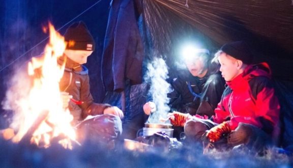 Partiolaiset telttailemassa lumen keskellä hämärässä