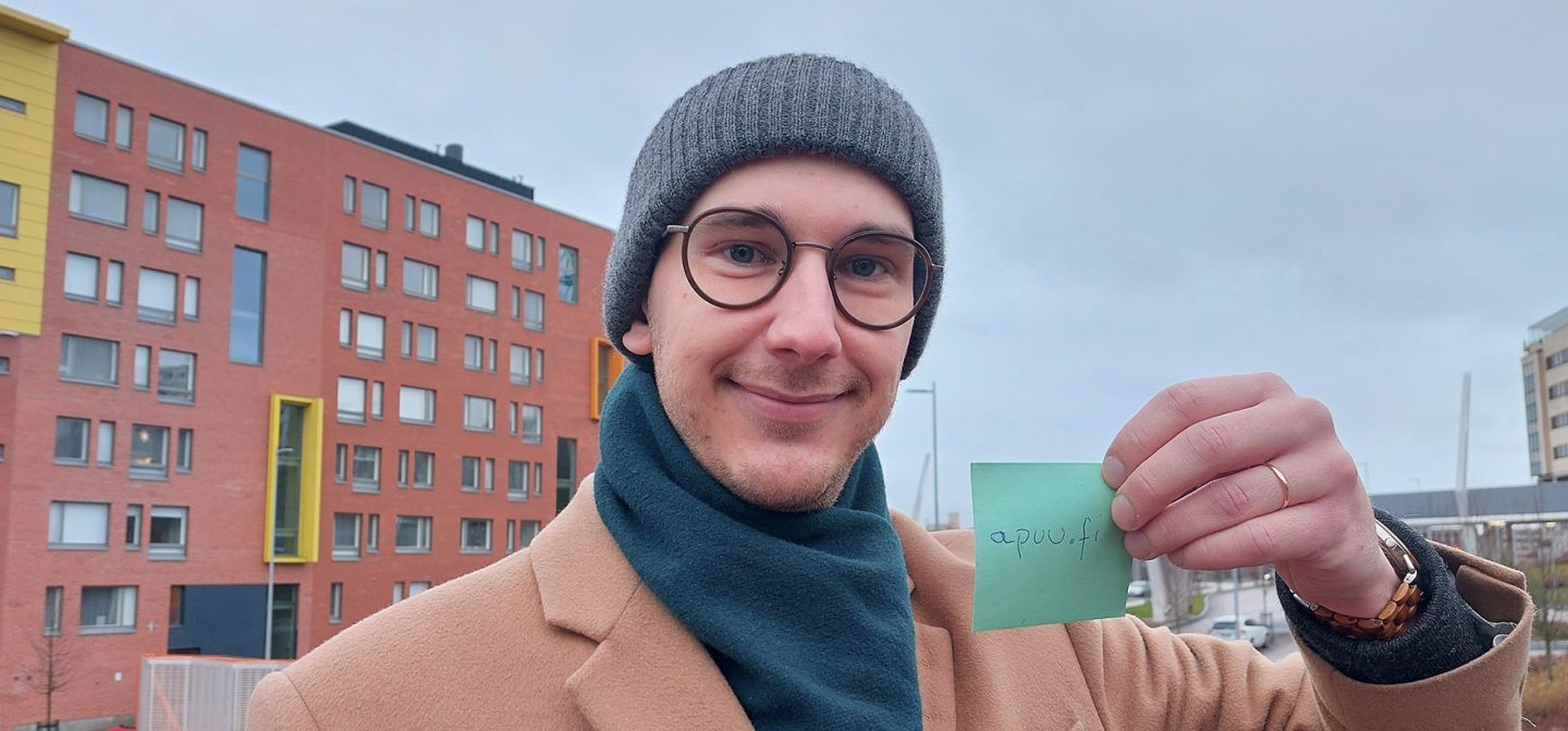 mies seisoo sillalla talojen edessä