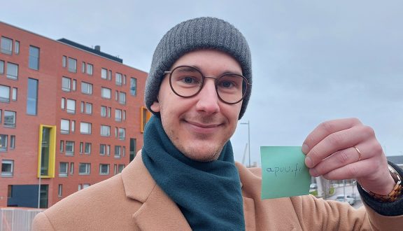 mies seisoo sillalla talojen edessä