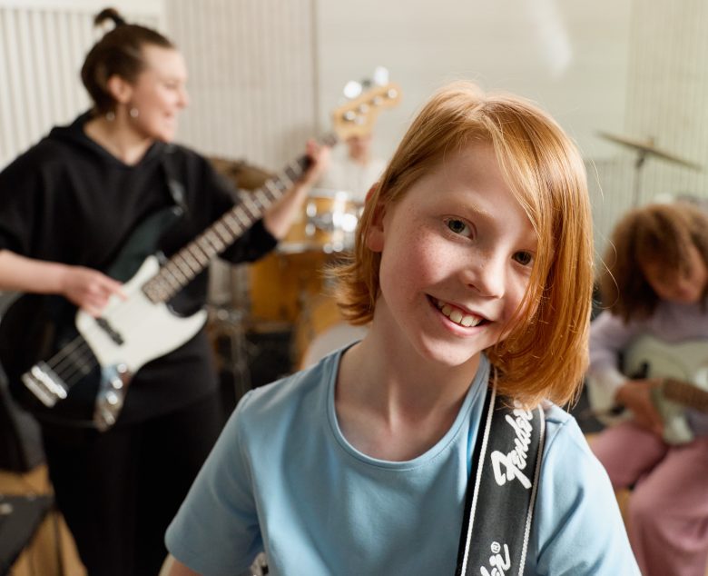 Iloinen poika soittaa kitaraa